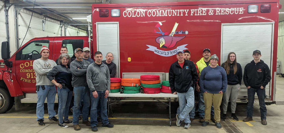 A photo of members of the Colon Community Fire Department standing in front of fire hoses and a fire engine.