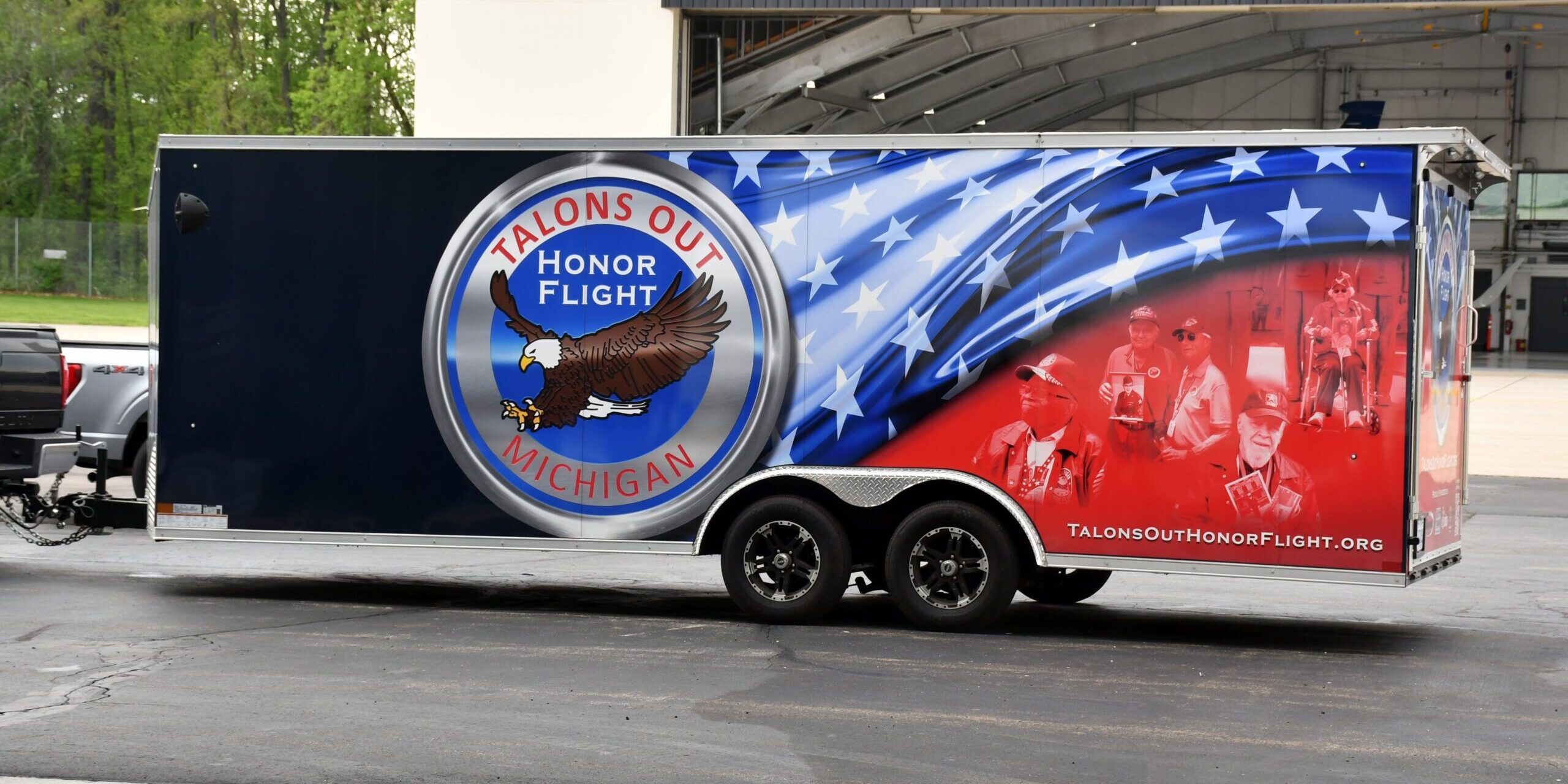 A large rectangular trailer with an eagle and American flag painted on the side.