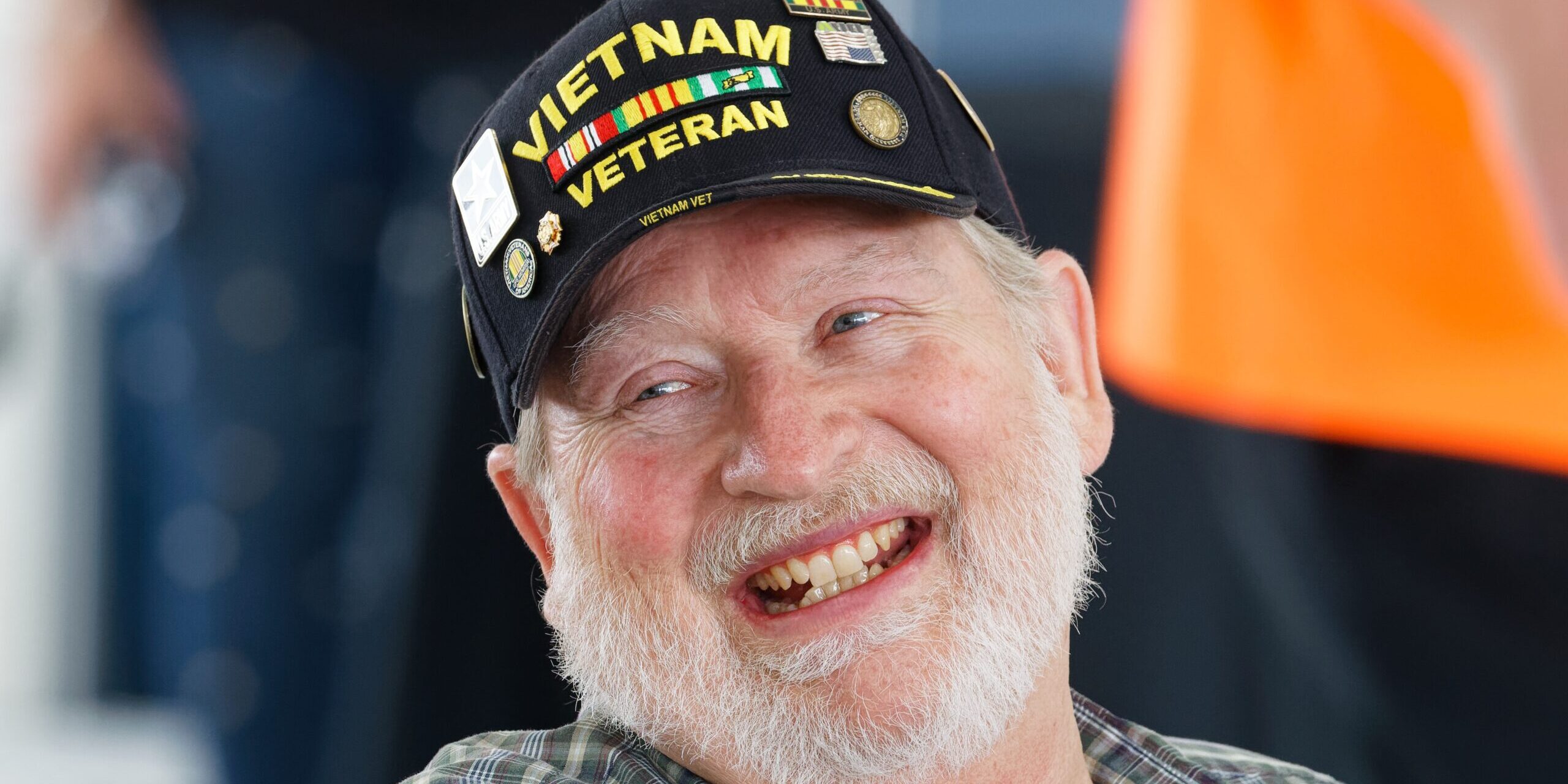 A gentleman with a white beard with a Vietnam War veteran hat on.