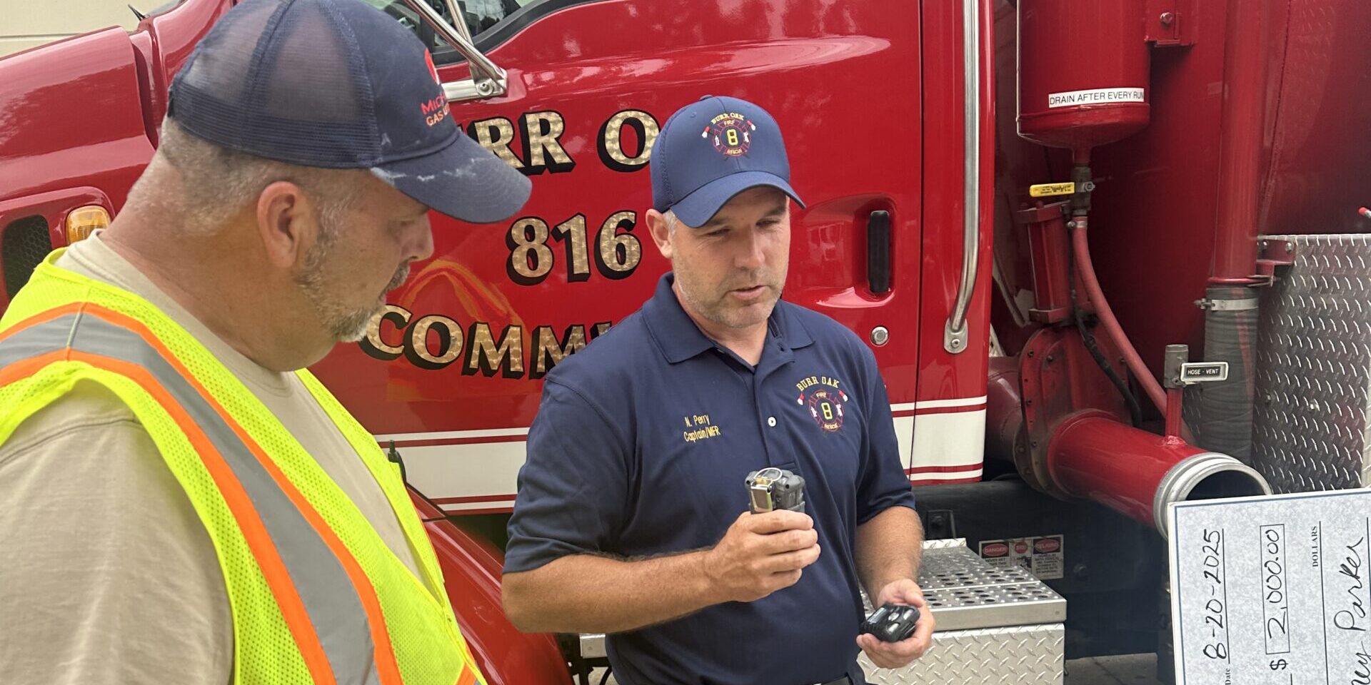 An MGU employee listens to a Burr Oak Fire Department firefighter talk about a multi-gas detector.