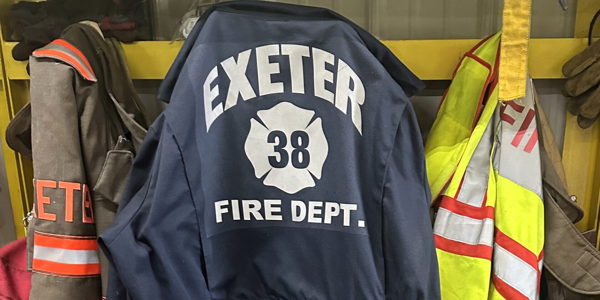 A blue jumpsuit with the words "Exeter Fire Department" printed in white on the back.