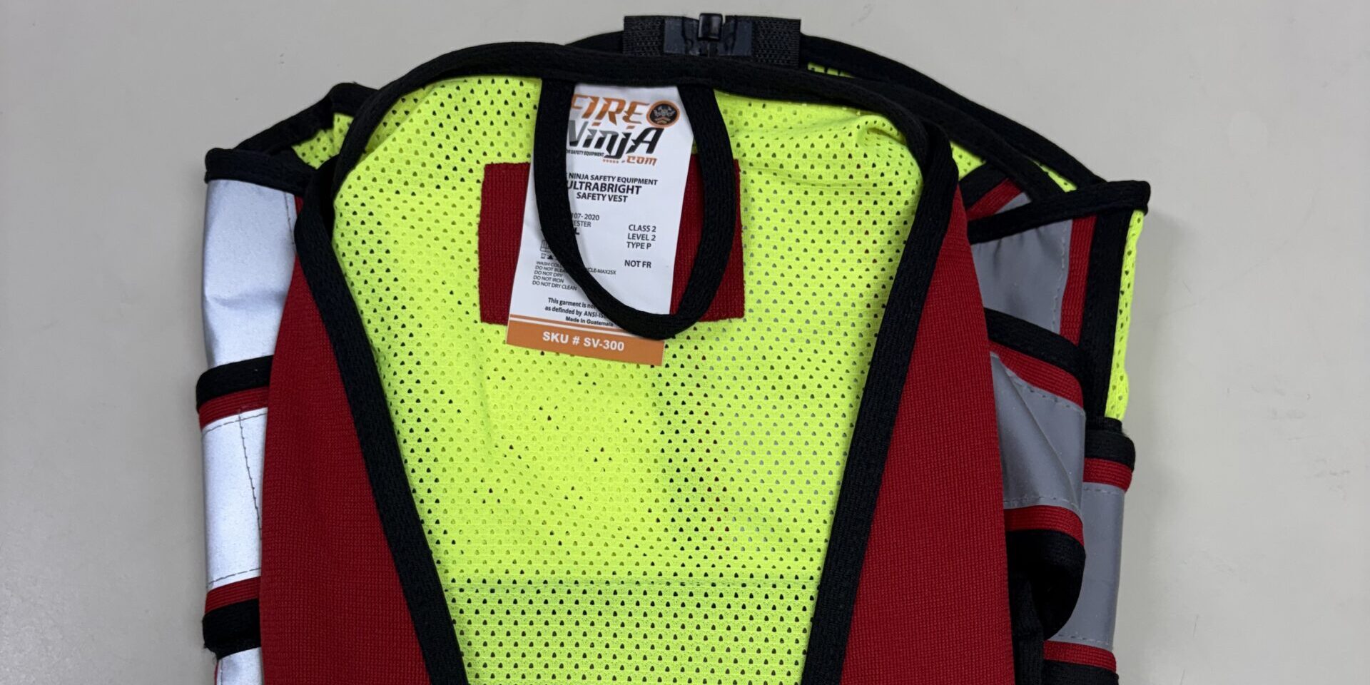 A neon-green vest with red accents folded on a table.